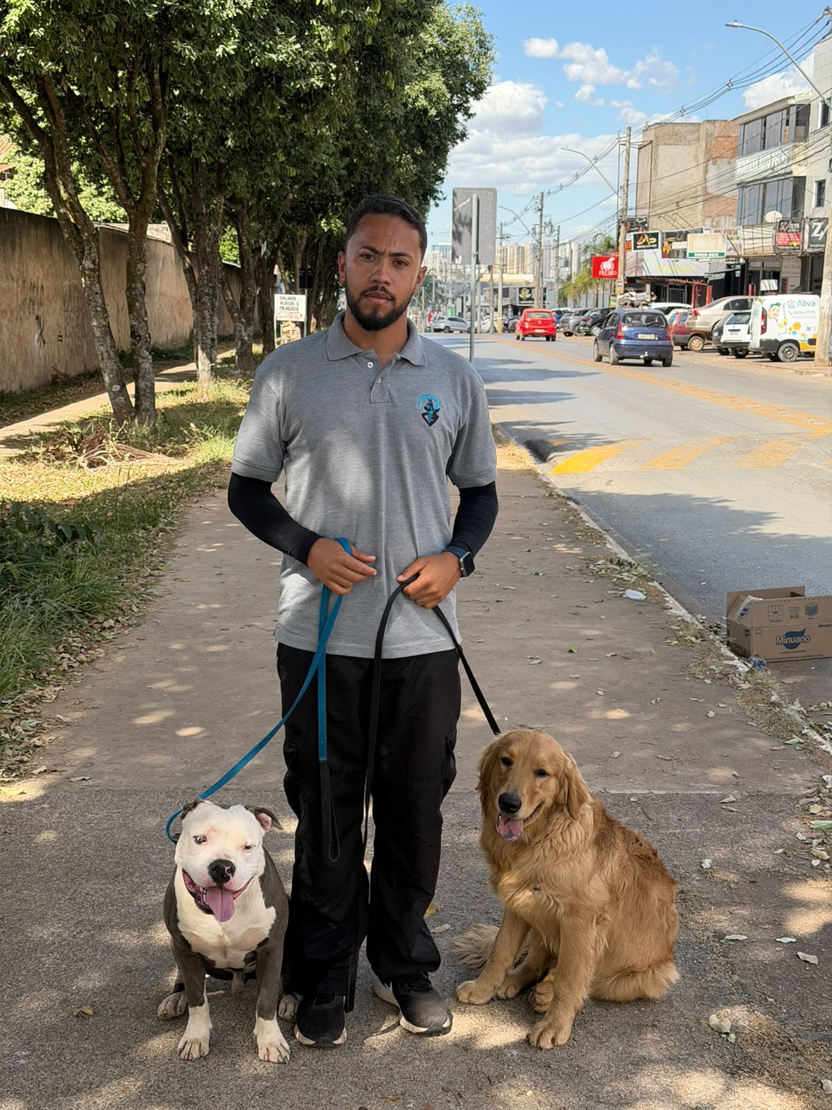 Lucas Alexandre em atendimento com dois cães de raças diferentes em Brasília